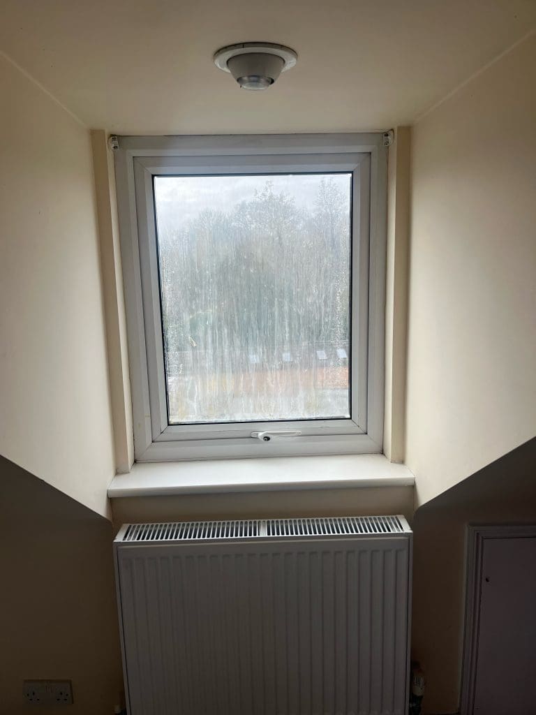 Misted white UPVC bedroom window showing internal condensation before repair